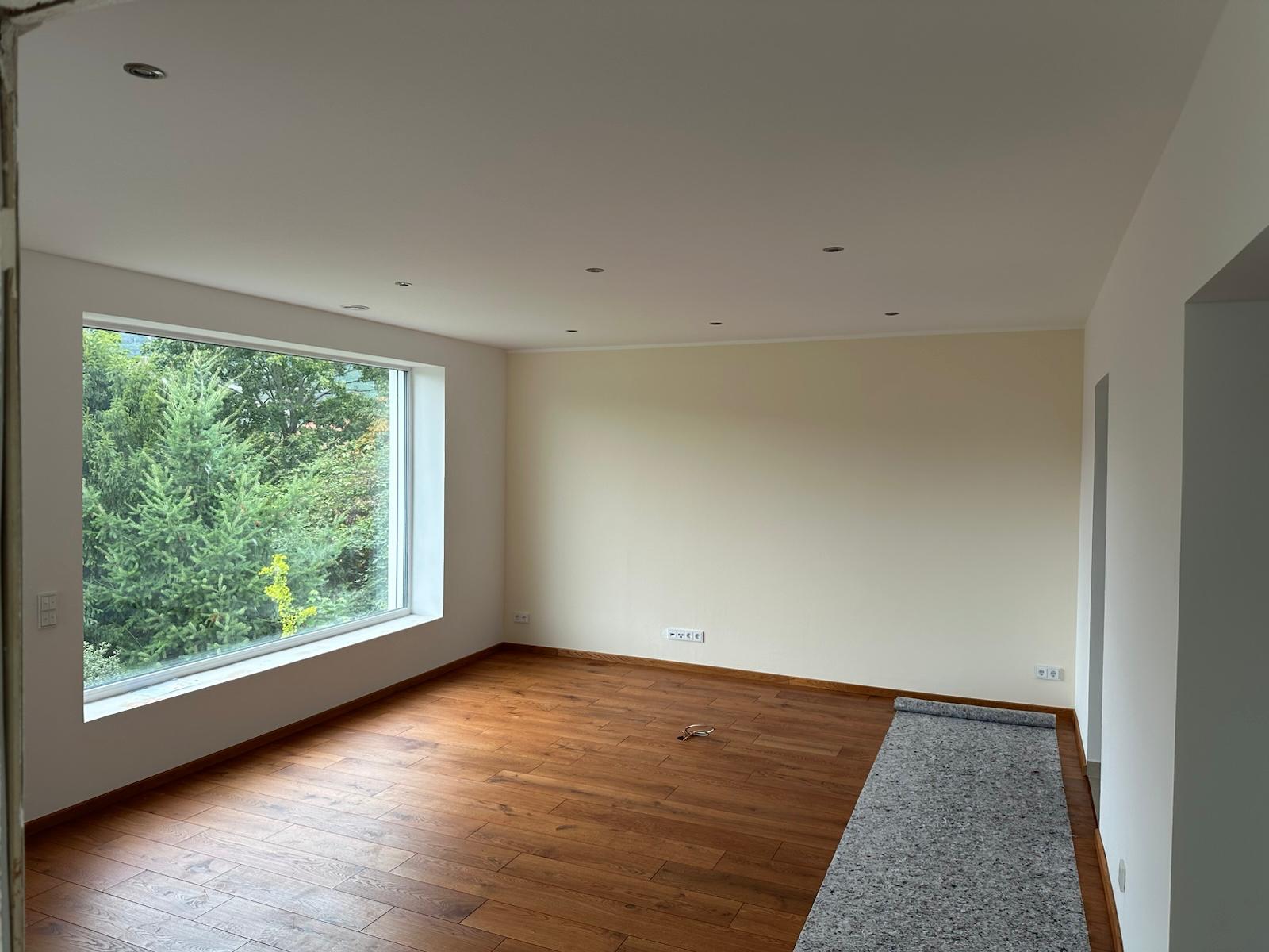 Fertig gestrichener Raum mit dunklem Parkett